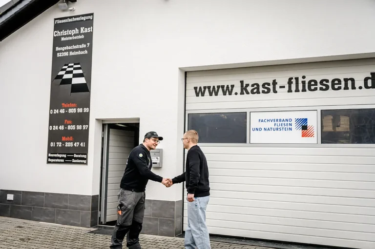 Der Fliesenlegermeister Christoph Kast grüßt einen potentiellen Auszubildenden sehr herzlich und symbolisiert das Top Arbeitsklima bei Fliesen Kast in Heimbach.